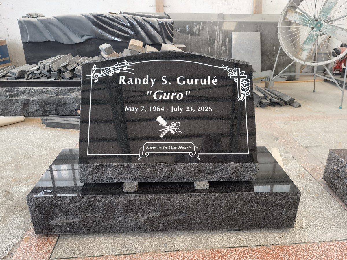 Sandblasted lettering, musical notes, floral cross and linework on black granite