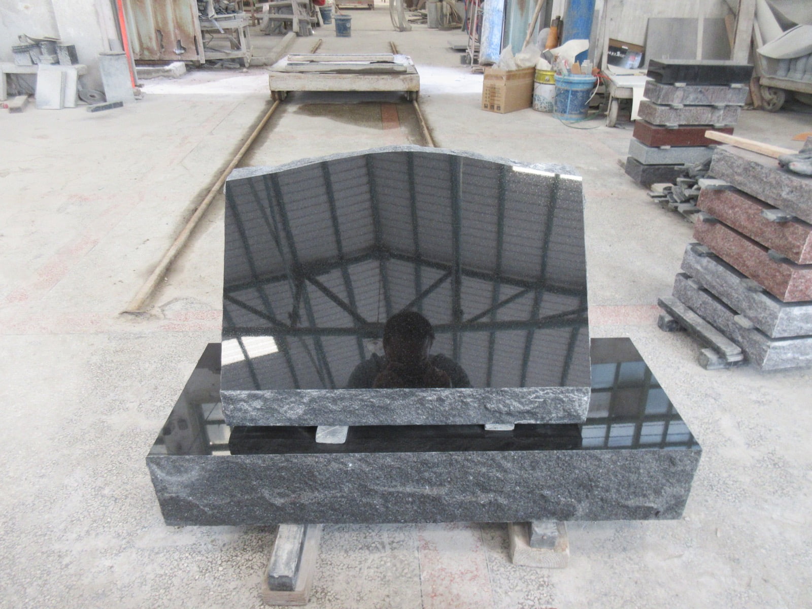 Unlettered black granite serpentine upright and matching base in the workshop