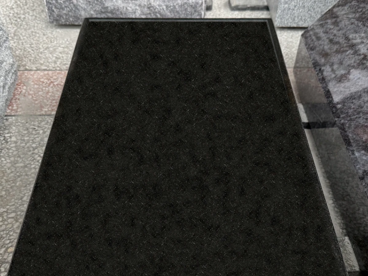 Blank dark polished granite surface prepared for lettering
