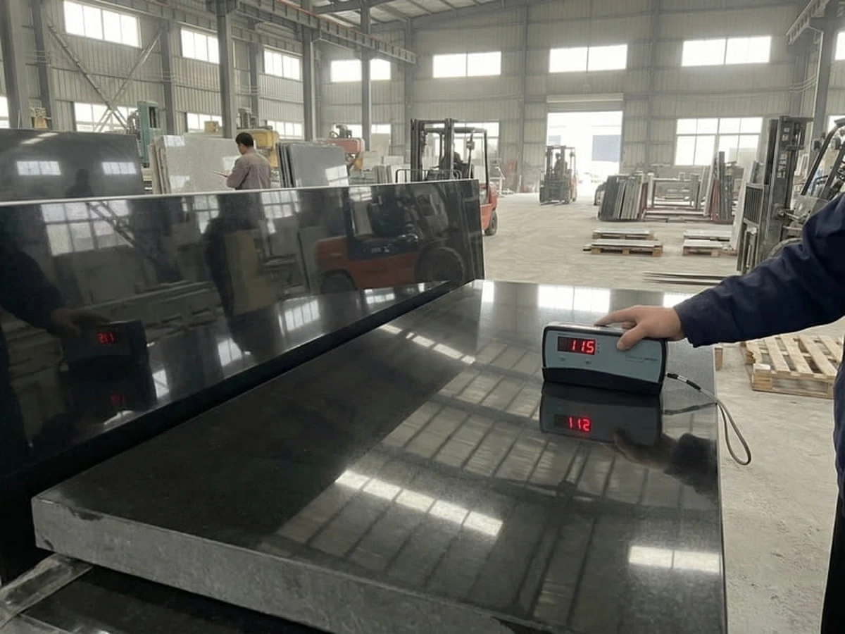 Gloss meter held against a polished black granite surface