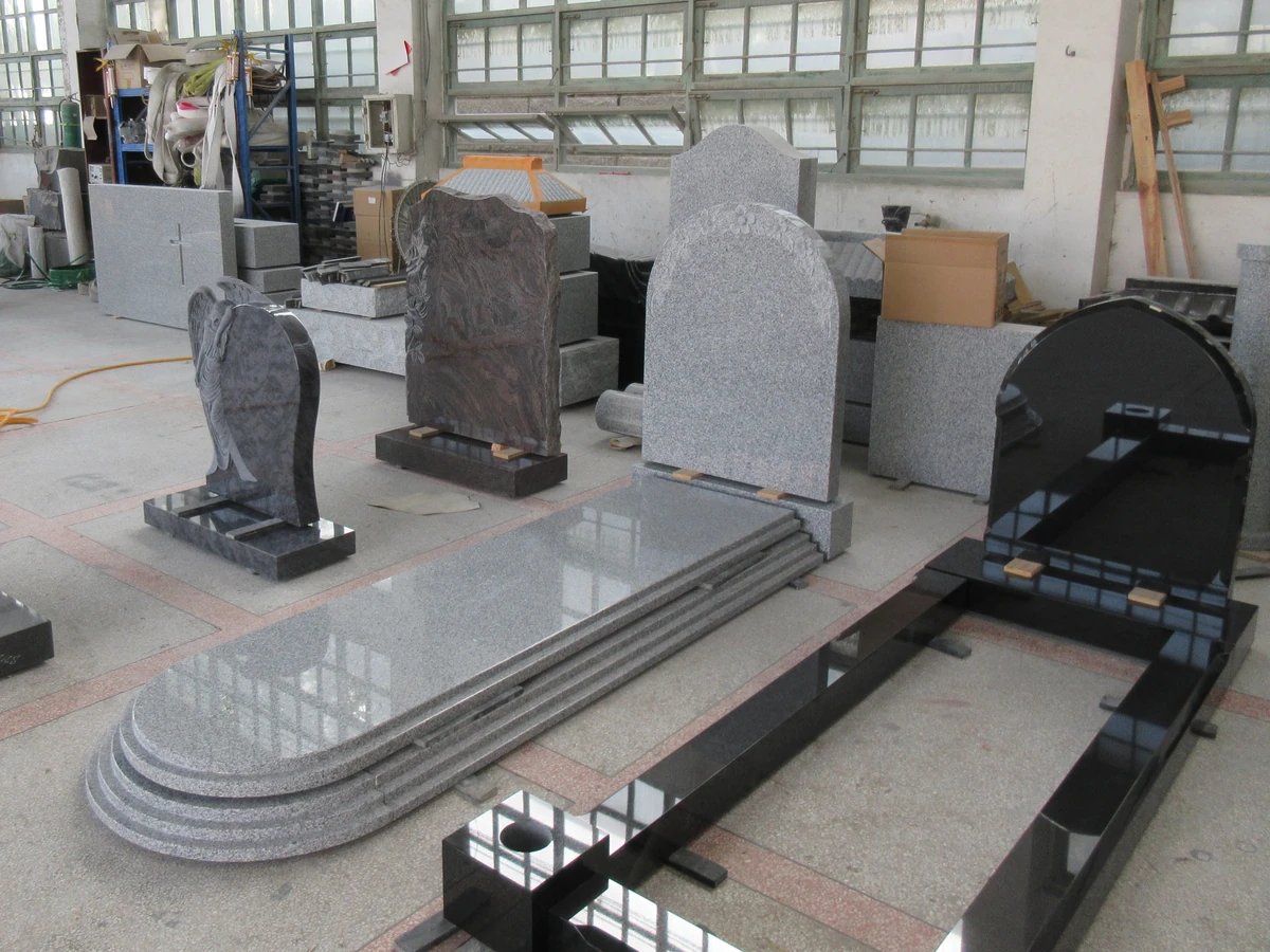 Complete granite memorial components set out together on a workshop floor